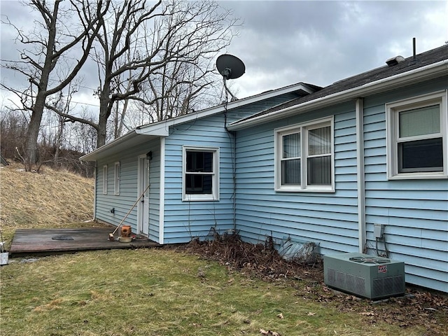 view of home's exterior with central air condition unit and a yard