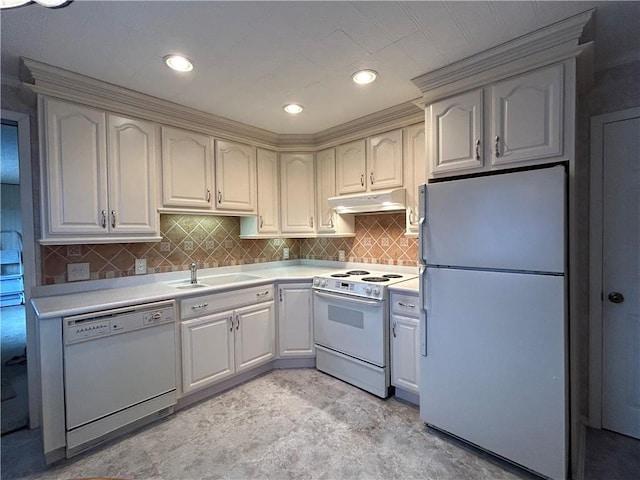 kitchen with white appliances, light countertops, under cabinet range hood, and a sink