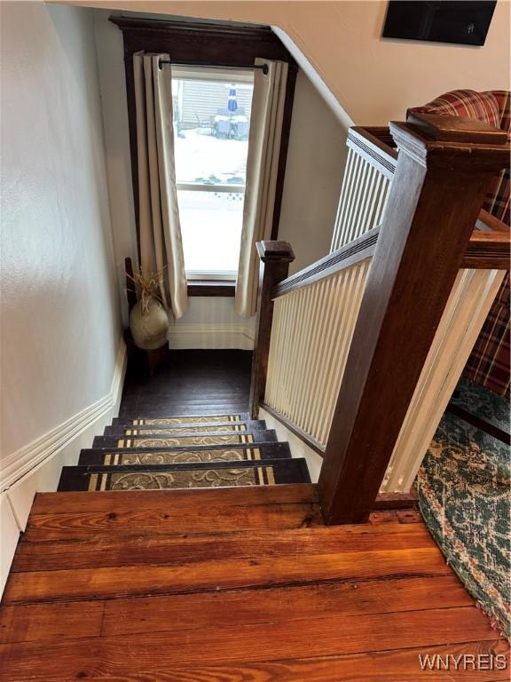 stairs with wood finished floors and baseboards