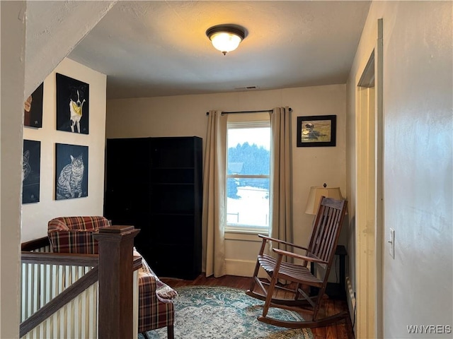 bedroom with wood finished floors, visible vents, and baseboards