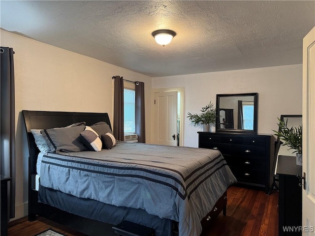 bedroom featuring dark wood-style floors and a textured ceiling