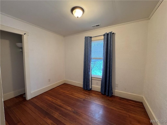 unfurnished bedroom featuring hardwood / wood-style flooring, baseboards, and visible vents