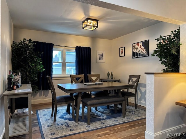 dining area with baseboards and wood finished floors