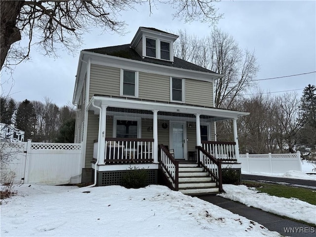 american foursquare style home with a porch and fence