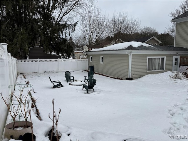 snowy yard featuring fence and a fire pit