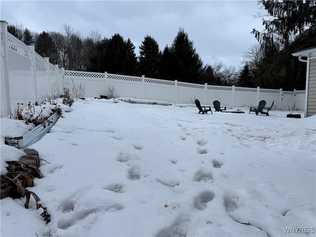 yard covered in snow featuring a fenced backyard