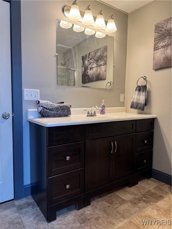 bathroom with a shower, vanity, and baseboards