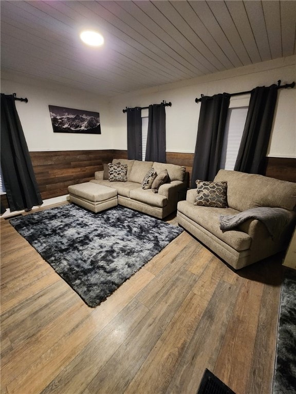 living room with a wainscoted wall, hardwood / wood-style floors, wooden ceiling, and wooden walls