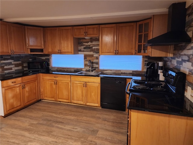 kitchen with dark countertops, a sink, black appliances, and exhaust hood