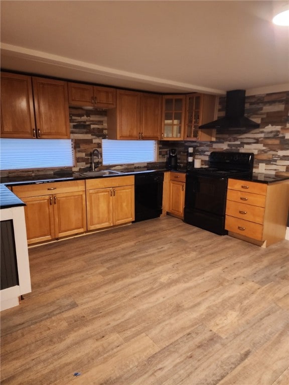 kitchen featuring dark countertops, black appliances, a sink, and exhaust hood