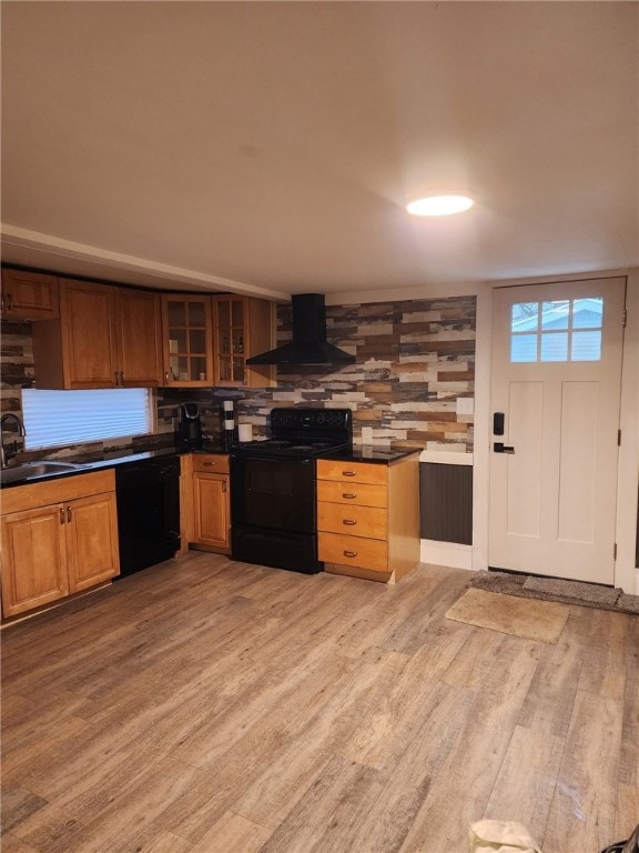 kitchen featuring ventilation hood, dark countertops, light wood-type flooring, and black appliances