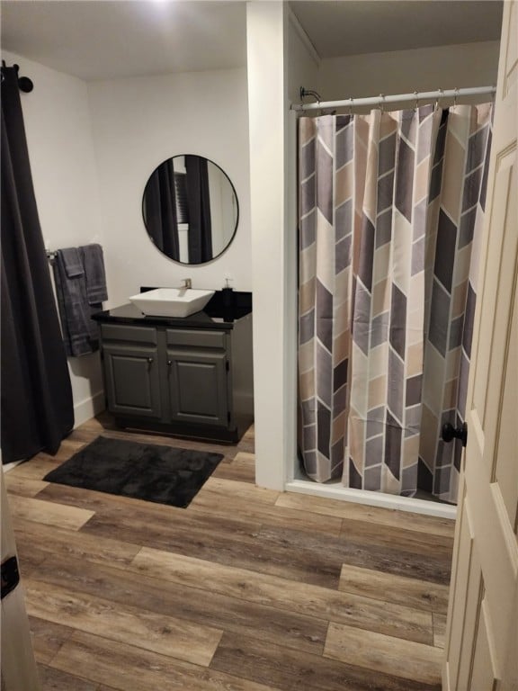 bathroom with vanity, a shower with shower curtain, and wood finished floors