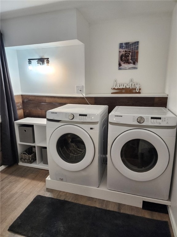 laundry area with laundry area, independent washer and dryer, and wood finished floors