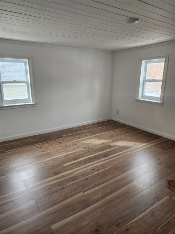 spare room featuring baseboards and wood finished floors