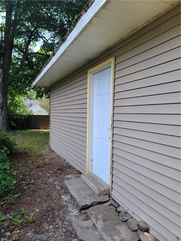 view of exterior entry featuring fence