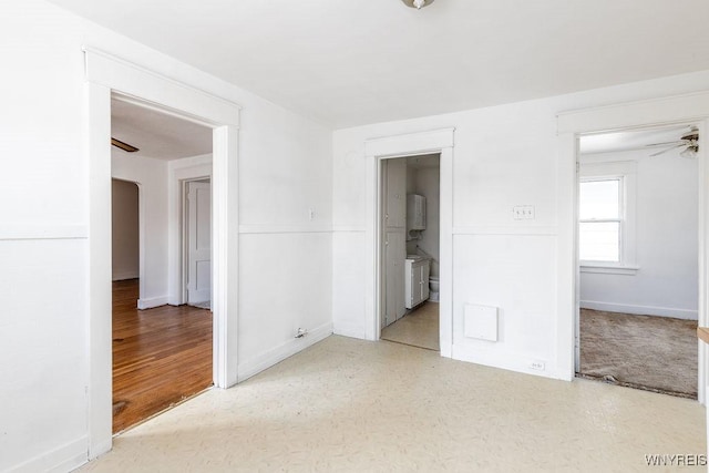 spare room with light floors, ceiling fan, and baseboards