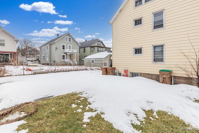 snowy yard with fence and a residential view