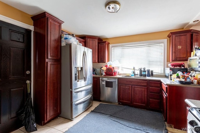 kitchen featuring light tile patterned floors, a sink, dark brown cabinets, appliances with stainless steel finishes, and light countertops