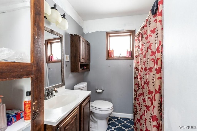 full bathroom featuring curtained shower, baseboards, vanity, and toilet