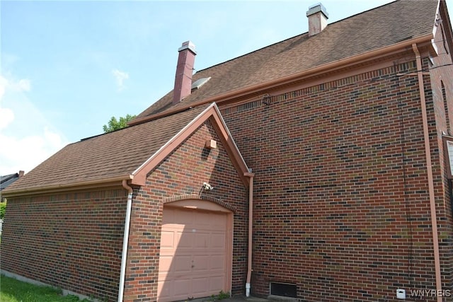 view of property exterior with a garage, roof with shingles, brick siding, and a chimney