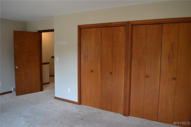 unfurnished bedroom with light carpet and baseboards