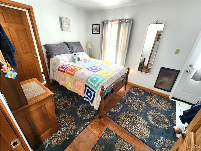 bedroom featuring wood finished floors and baseboards