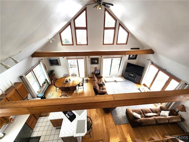 unfurnished living room featuring plenty of natural light, wood-type flooring, and high vaulted ceiling