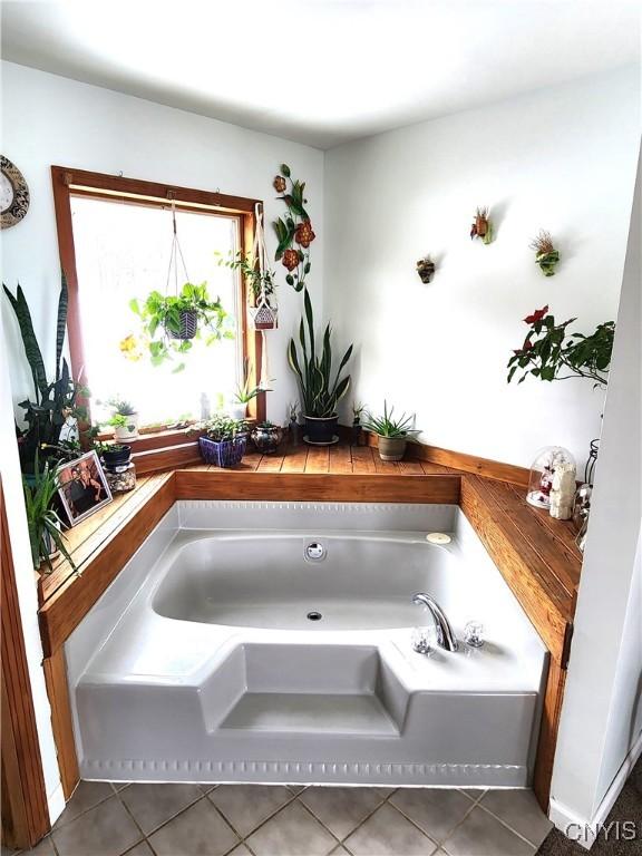 full bath with tile patterned flooring and a bath