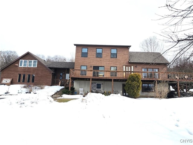 snow covered house featuring a deck