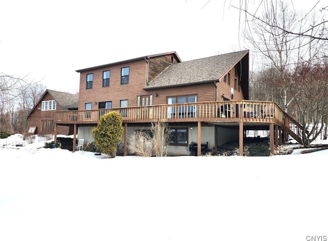 snow covered property featuring a deck and stairs