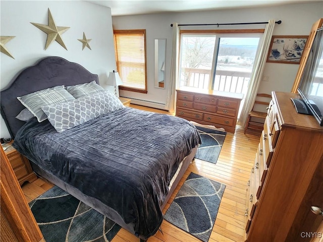 bedroom with light wood-style floors and a baseboard heating unit