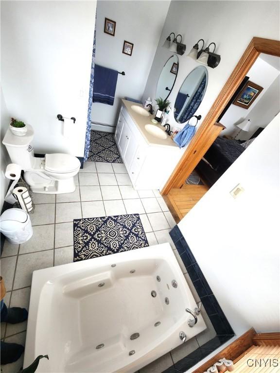 full bathroom featuring a sink, a tub with jets, and tile patterned flooring