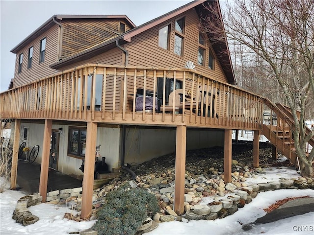 snow covered house with a deck