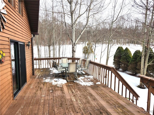 snow covered deck featuring outdoor dining area