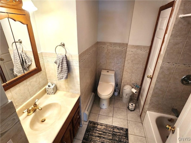 bathroom featuring tile walls, toilet, a baseboard heating unit, vanity, and tile patterned flooring