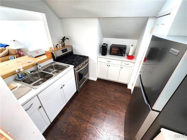 kitchen with appliances with stainless steel finishes, light countertops, white cabinets, and a sink