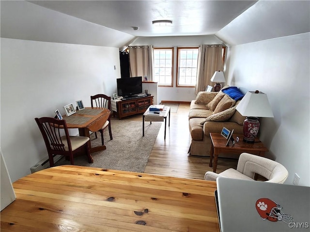 sitting room featuring vaulted ceiling, a baseboard heating unit, and light wood-type flooring