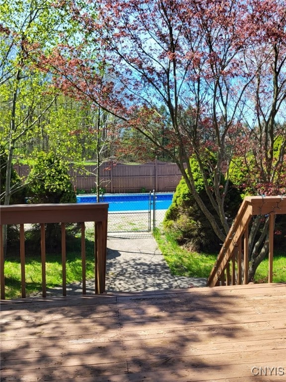 wooden terrace with fence and a fenced in pool