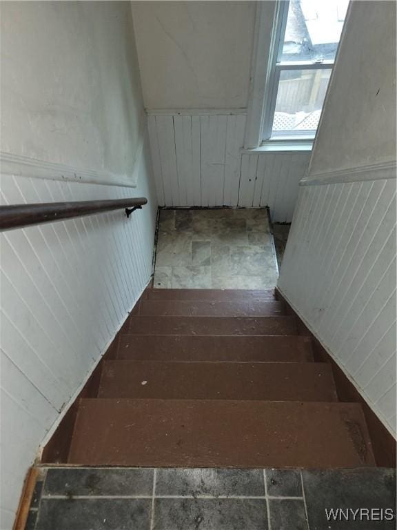 stairway featuring wainscoting and hardwood / wood-style flooring