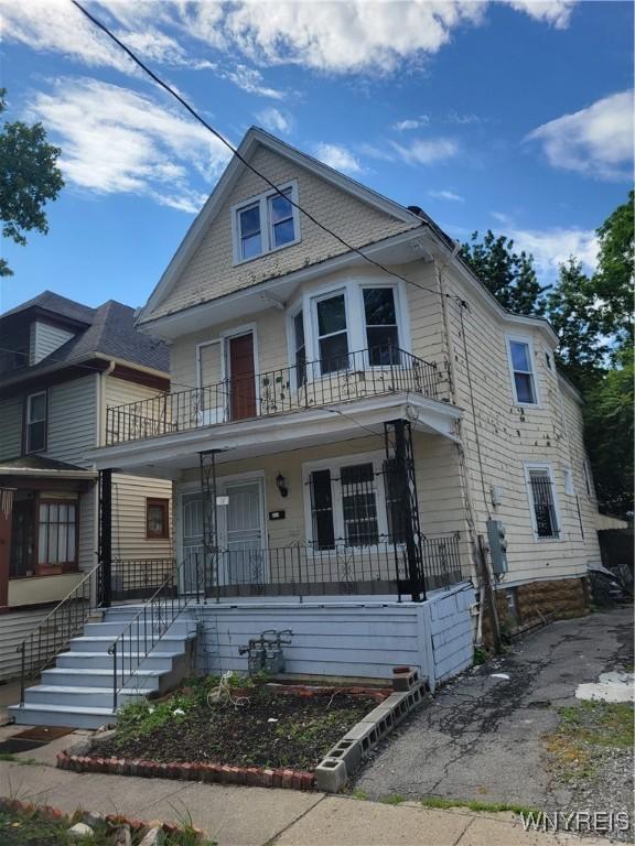 view of front of property featuring a porch and a balcony