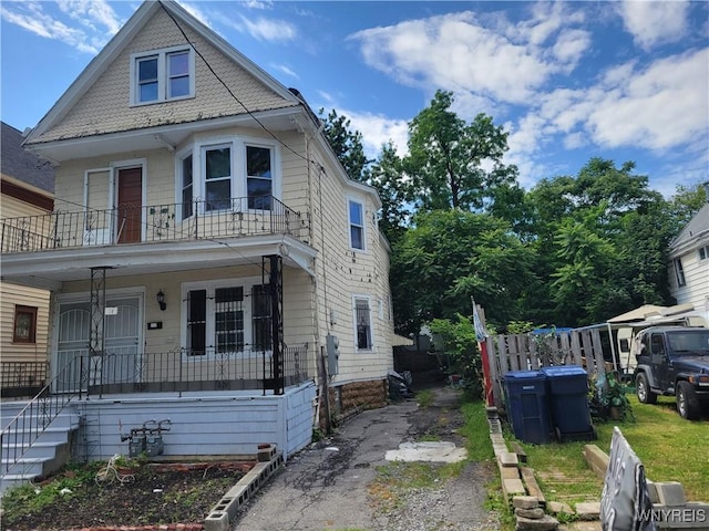 view of front of home featuring covered porch, aphalt driveway, and a balcony