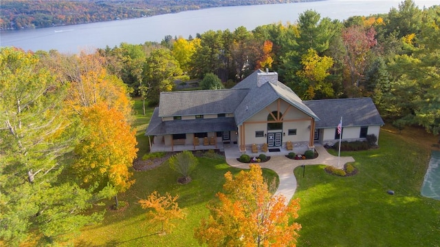 birds eye view of property featuring a water view and a view of trees