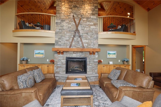 living room with wooden ceiling, a fireplace, a high ceiling, and wood finished floors