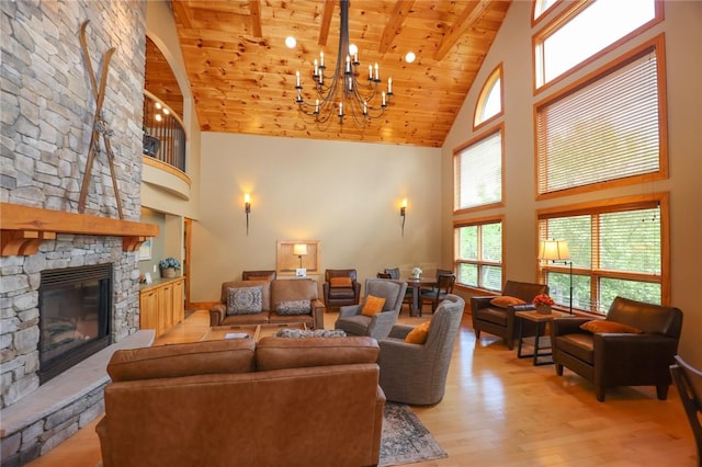 living room featuring a fireplace, light wood finished floors, an inviting chandelier, wood ceiling, and high vaulted ceiling