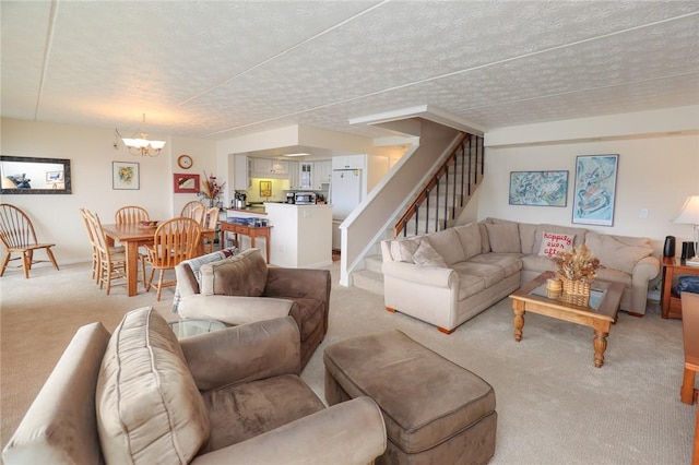 living room with stairway, a chandelier, a textured ceiling, and light colored carpet