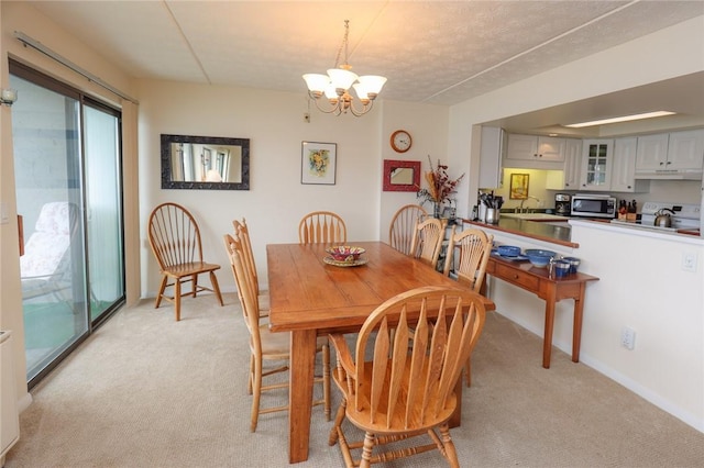 dining area with light carpet and a chandelier