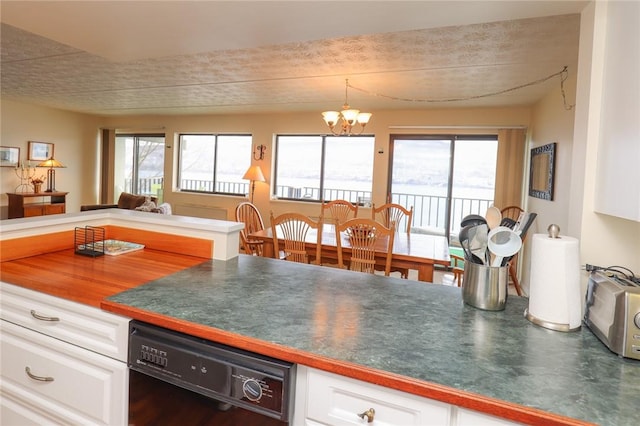 kitchen featuring black dishwasher, white cabinetry, plenty of natural light, and an inviting chandelier