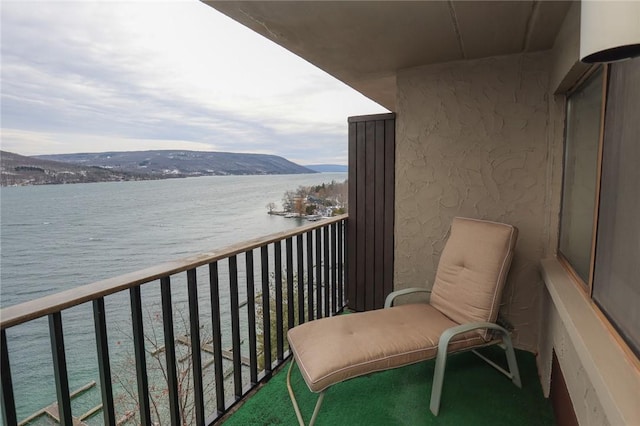 balcony featuring a water and mountain view