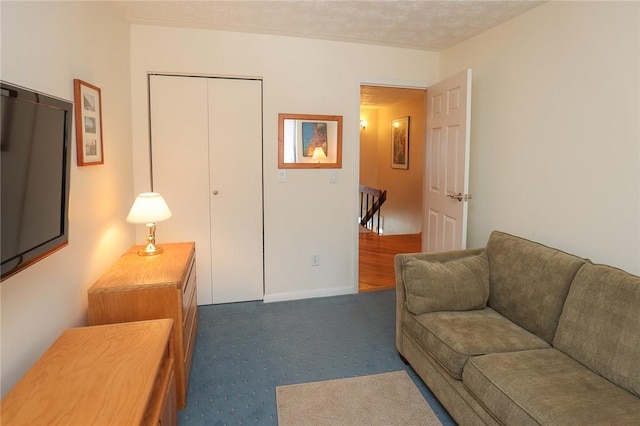 living area featuring carpet floors and a textured ceiling