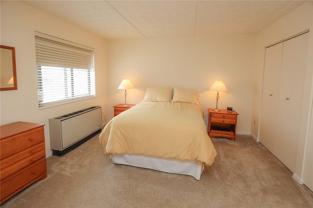 bedroom with light carpet, radiator heating unit, and a closet